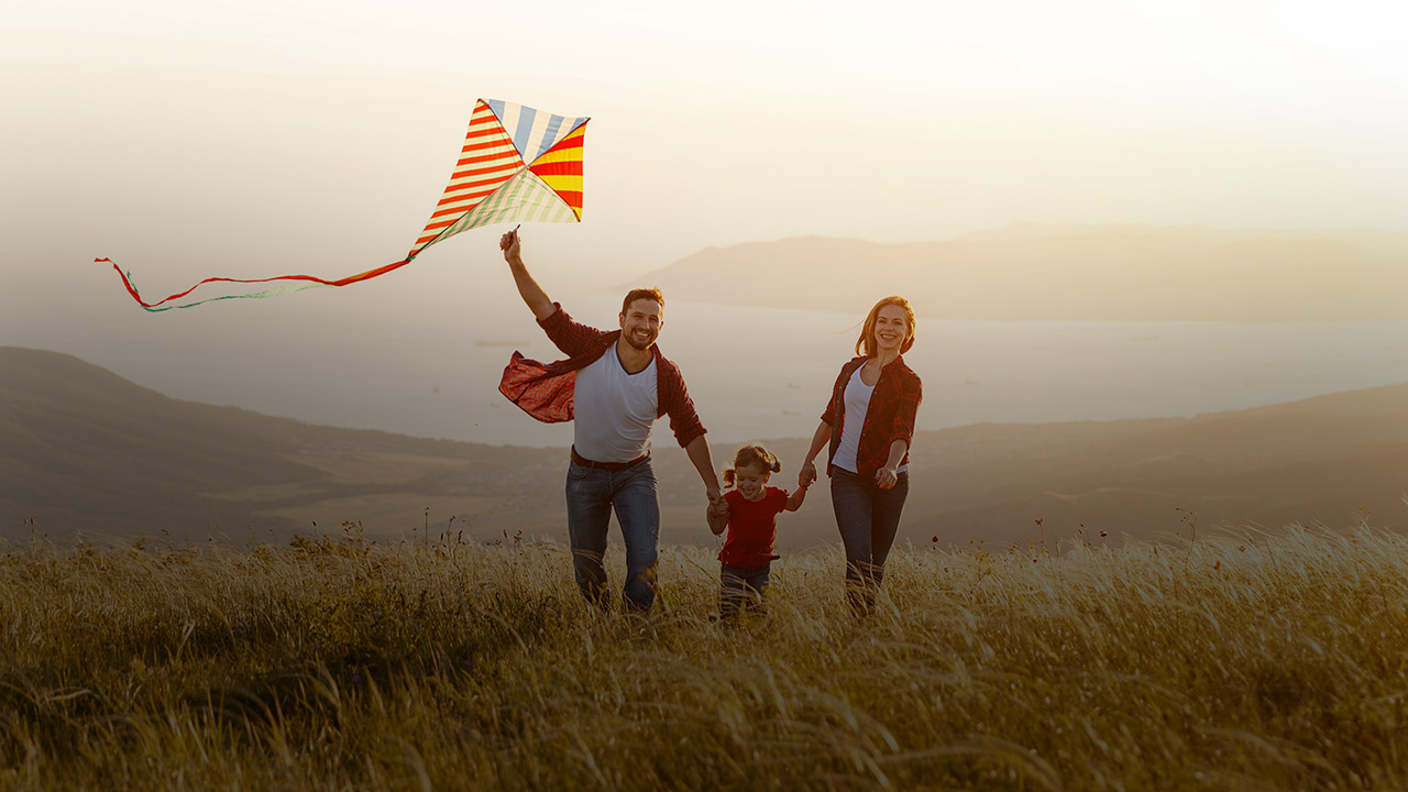 Eine junge Familie lässt einen Drachen steigen.
